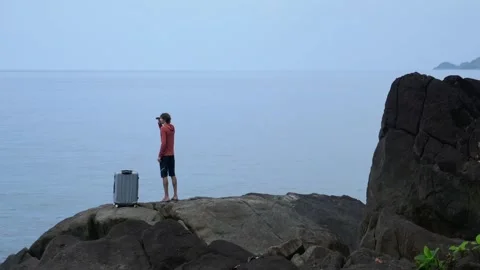 A lost man on the seashore with a suitcase, asking for help Stock Footage 293189821