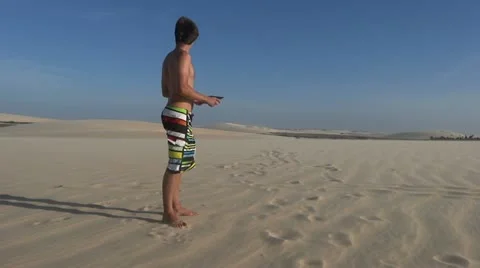 Lost man using digital tablet for navigation in the desert Stock Footage 20616182