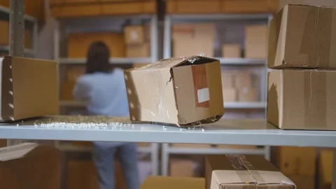 A lost parcel in a warehouse, against the background of a working person Stock Footage 272424729