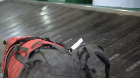 Lost single backpack forgotten on an empty modern luggage belt in the airport Stock Footage 63946235