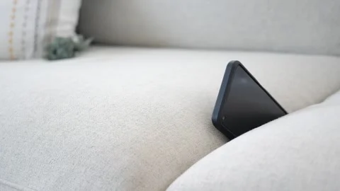 Lost Smartphone Hidden Between Sofa Cushions On A Light Beige Couch In A Cozy Stock Footage 333444374