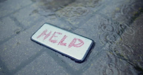 Lost smartphone on wet ground with text Help on the screen,rainy day,crime scene Stock Footage 131976917