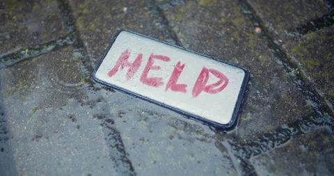 Lost smartphone on wet ground with text Help on the screen,rainy day,crime scene Stock Footage 131977583