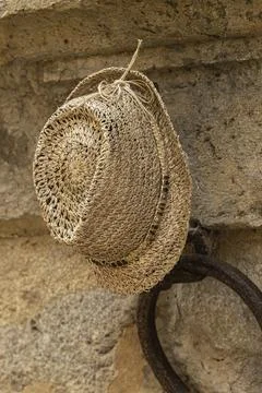 A Lost Straw Hat Hanging On A Wall Stock Photos