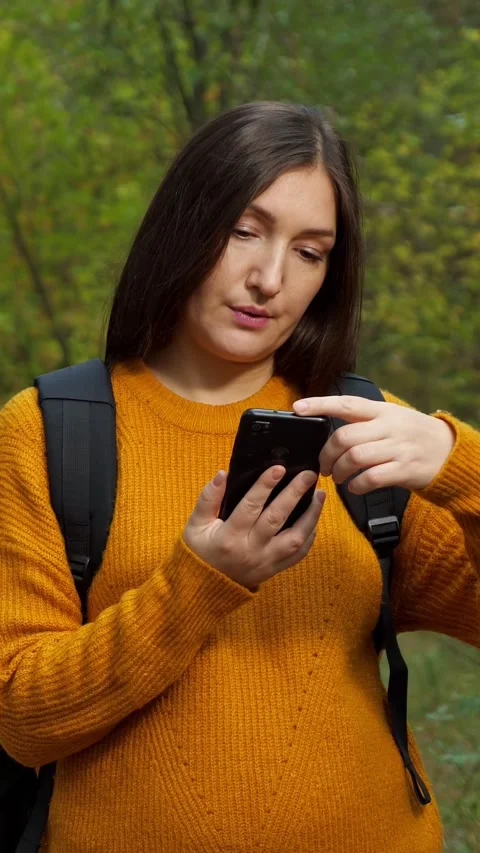 Lost tourist hiker using smartphone gps for navigation while trekking in the Stock Footage 344798832