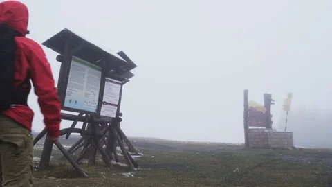 Lost tourist reading map and looking for shelter from the rain Stock Footage 119639613