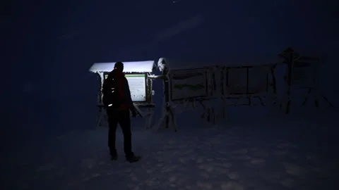 Lost tourist using headlamp to read wooden signs in the mountain Stock Footage 146972577