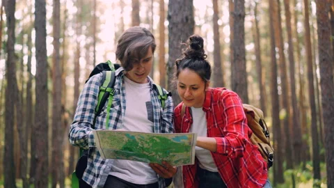 Lost tourists are standing in forest looking at map, talking and gesturing then Video stock 94802280