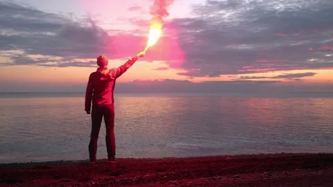 Losted Man on a Beach Holding Emergency Fire, Rescue Concept. Stock Footage 169921975