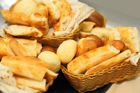 A lot of bread and rolls on the table in baskets Stock-Fotos