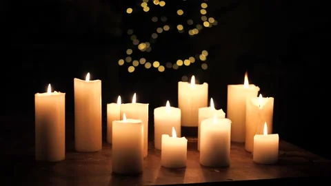 A lot of Candles burning with light up tree in the background, dark room setting 스톡 동영상 219458210