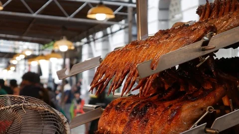 A lot of cooked chicken pieces grills hang on metal skewers in the kitchen Stock Footage 112972743