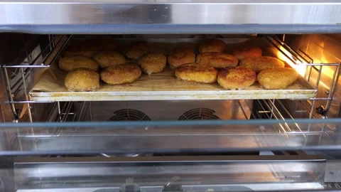 A lot of cutlets on a baking sheet in a large oven in the restaurant kitchen. Stock Footage 318659776