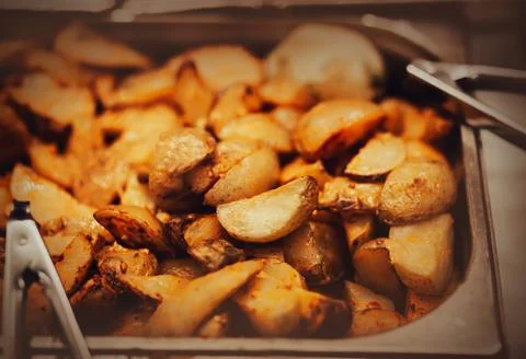 A lot of delicious appetizing fried rustic potatoes are in the fryer, next to Stock Photos