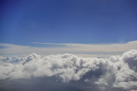 Lot of dense clouds over a blue sky during a flight Foto stock