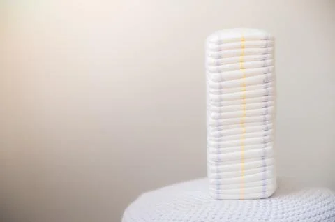 A lot of diapers in a stack close-up and copy space. Newborn, diapers, ecology. Stock Photos