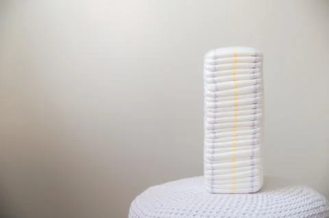 A lot of diapers in a stack close-up and copy space. Newborn, diapers, ecology. Stock Photos