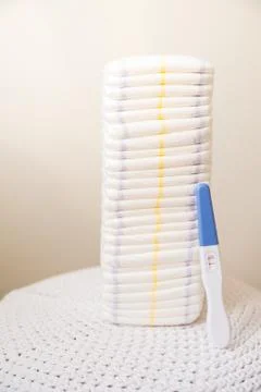 A lot of diapers in a stack close-up and copy space. Diapers and a positive preg Stock Photos