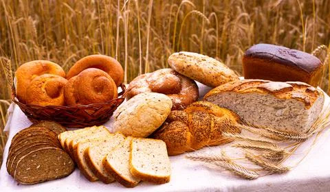 Lot of different flavored bread, wheat, rye, on the table in the field outside Foto stock