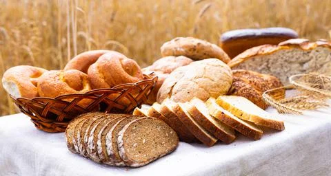 Lot of different flavored bread, wheat, rye, on the table in the field outside Foto stock