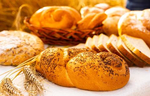 Lot of different flavored bread, wheat, rye, on the table in the field outside Stock Photos