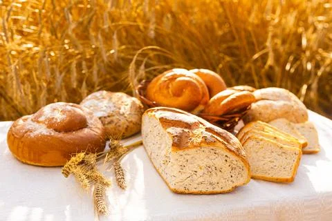 Lot of different flavored bread, wheat, rye, on the table in the field outside Foto stock