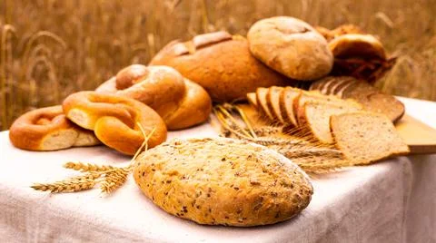 Lot of different flavored bread, wheat, rye, on the table in the field outside Foto stock