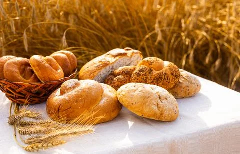 Lot of different flavored bread, wheat, rye, on the table in the field outside Foto stock