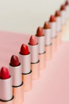 A lot of different lipsticks stand on a beige and pink background. Pattern .. 写真素材