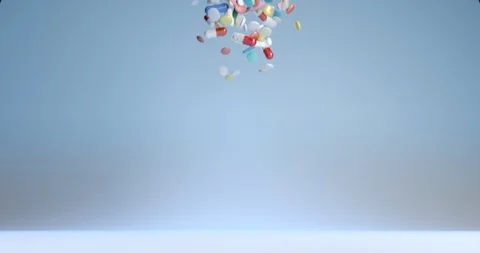 A lot of falling medicaments on a simple blue background. Colored capsules and Stock Footage