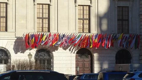 A lot of flags are blowing with the wind in facade of one building Stock Photos