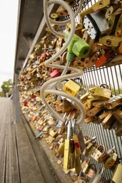 Lot hinged barn locks on the wall above the river, padlock on the bridge Stock Photos