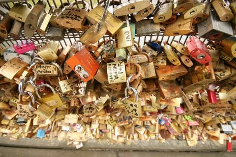 Lot hinged barn locks on the wall above the river, padlock on the bridge Stock Photos