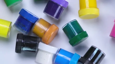 A lot of jars with multi-colored paints on a white background, the concept of Stock Footage 218306350