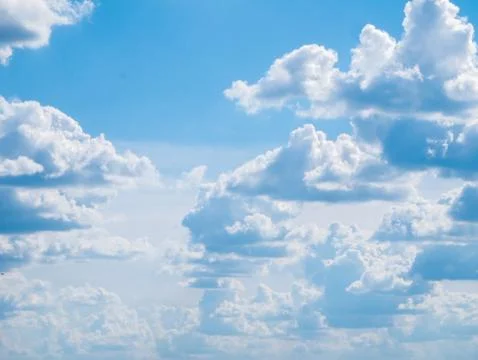 A lot of medium-sized fluffy clouds with a flat bottom against a large bright Stock Photos