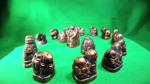 A Lot of Mongolian Iron Figures Move in a Circle on a Green Background Stock Footage 62635975