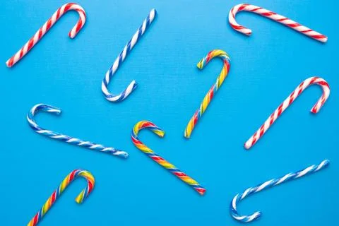 Lot of multi-colored candy canes on a blue background, copy space Stock Photos