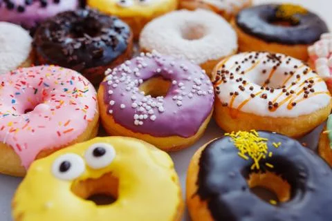 A lot of multi-colored donuts with different fillings, top view Stock Photos