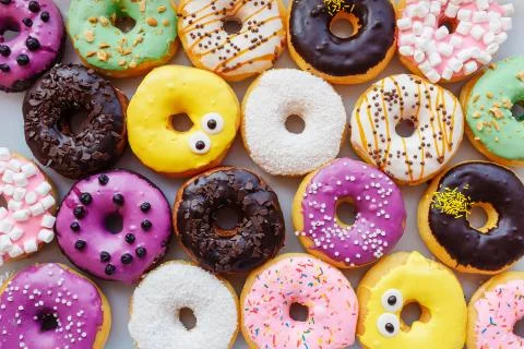 A lot of multi-colored donuts with different fillings, top view Stock Photos
