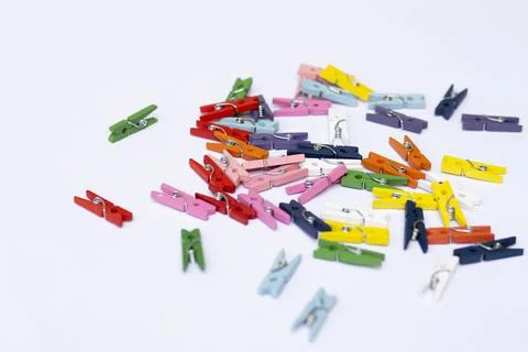 A lot of multi-colored mini clothespins on a white background Stock Photos