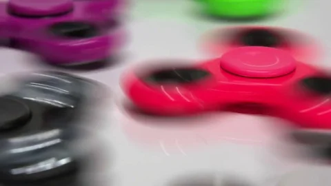 A lot of multi-colored spinners close-up on a white background Stock Footage 77735603