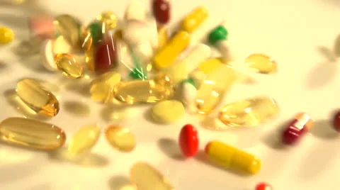 A lot of multicolored tablets and capsules fall, filling the entire screen. Stock-Footage 55339713