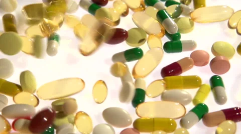 A lot of multicolored tablets and capsules fall, filling the entire screen. 스톡 동영상 55339751