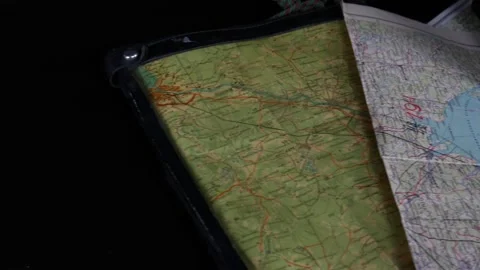 A lot of old maps on the black table. Old phone, notebook, pencils 스톡 동영상 102228724