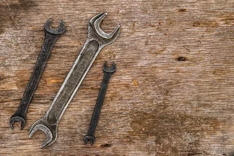A lot of old wrenches. The working set of wrenches on cracked plywood background Stock Photos
