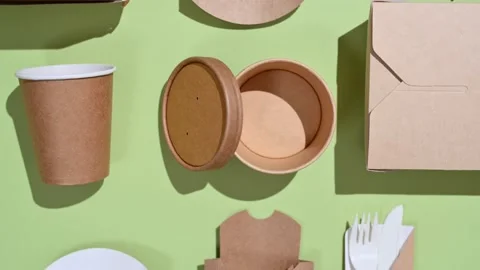 A lot of paper disposable tableware is stacked evenly on a green background. Stock Footage 227212339