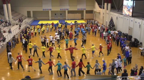 A lot of people walk  in a circle in a large hall Stock Footage