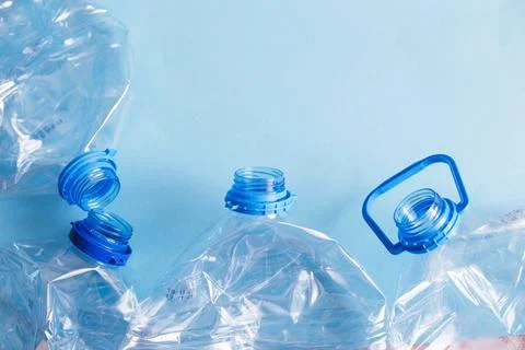 A lot of plastic empty rumpled used bottles on a blue background. waste and p Fotos Stock