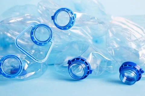 A lot of plastic empty rumpled used bottles on a blue background. waste and p Stock Photos
