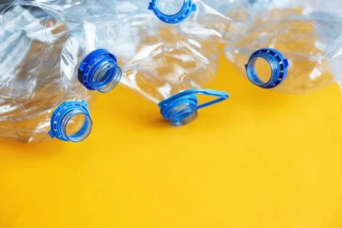 A lot of plastic empty rumpled used bottles on a yellow background. waste and 스톡 사진